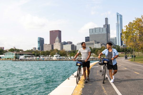 Two people walking bikes along lakefront